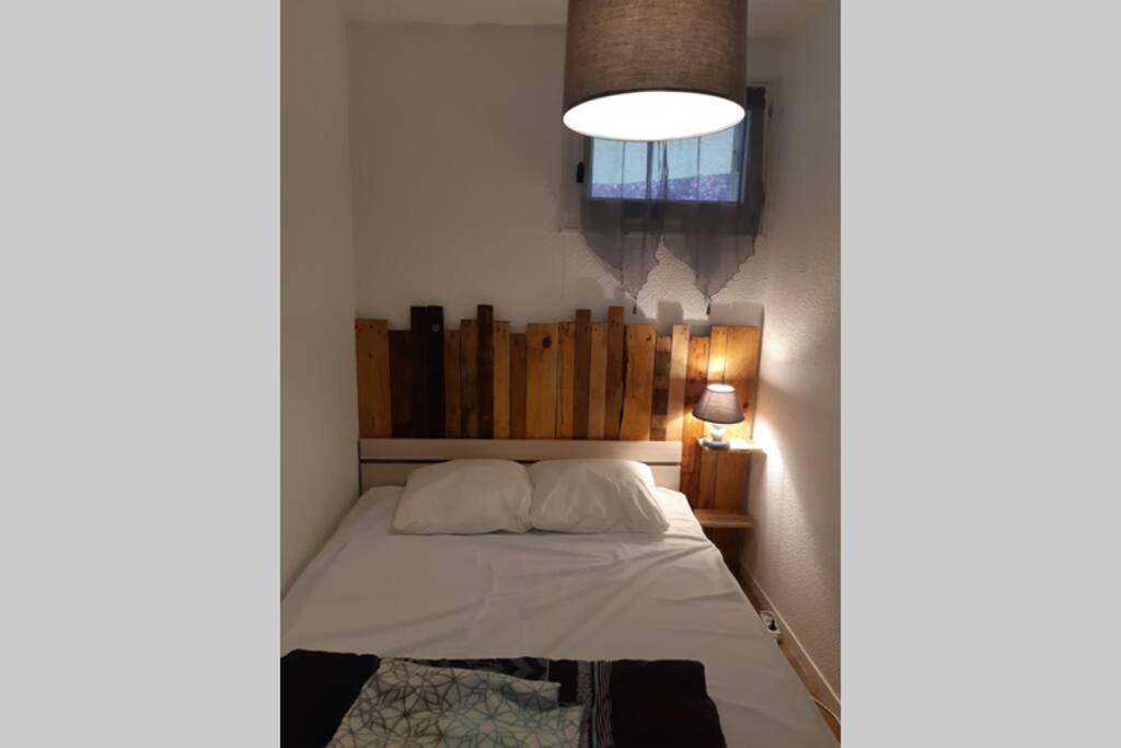 - une chambre avec un lit, une lampe et une fenêtre dans l'établissement appartement T2 cabine en RDC avec terrasse, à Saint-Lary-Soulan