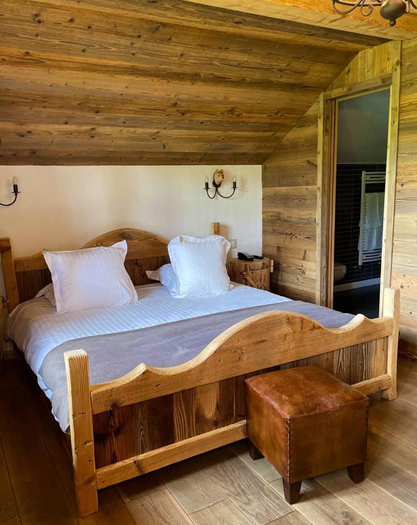 - une chambre avec un grand lit en bois dans une cabine dans l'établissement Le Tillau, à Les Verrières-de-Joux
