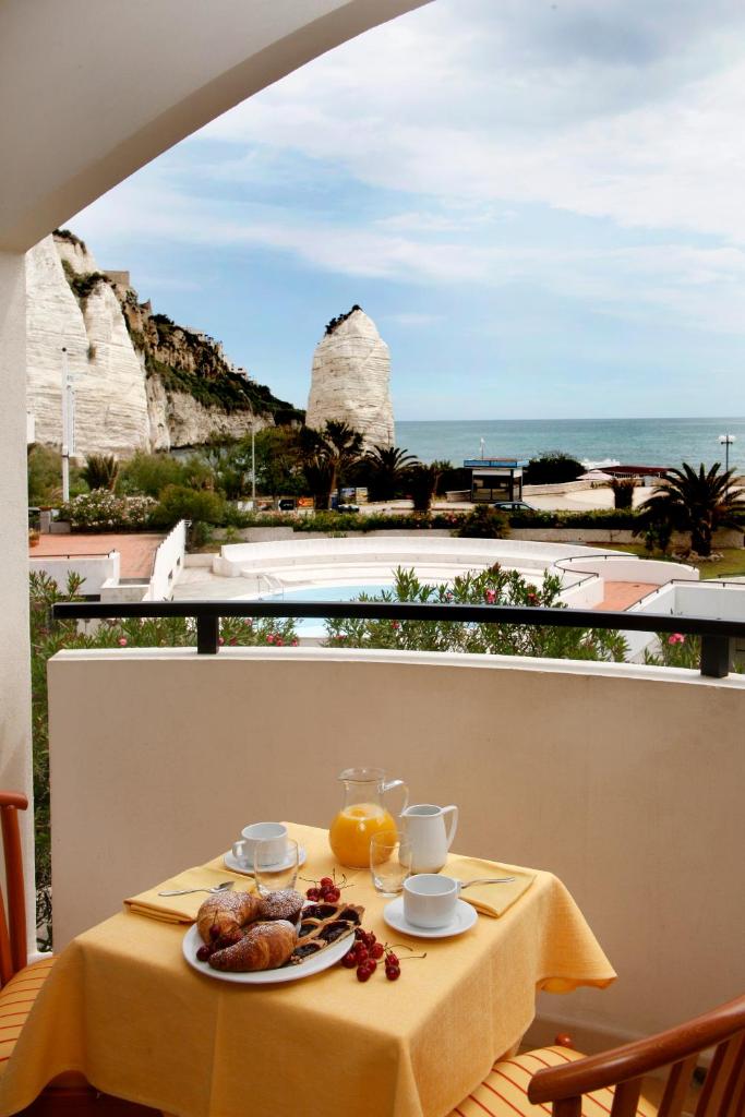 une table avec de la nourriture dessus avec vue sur l'océan dans l'établissement Bikini Hotel, à Vieste