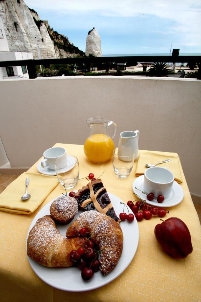 une table avec un plateau de pâtisseries sur une table dans l'établissement Bikini Hotel, à Vieste