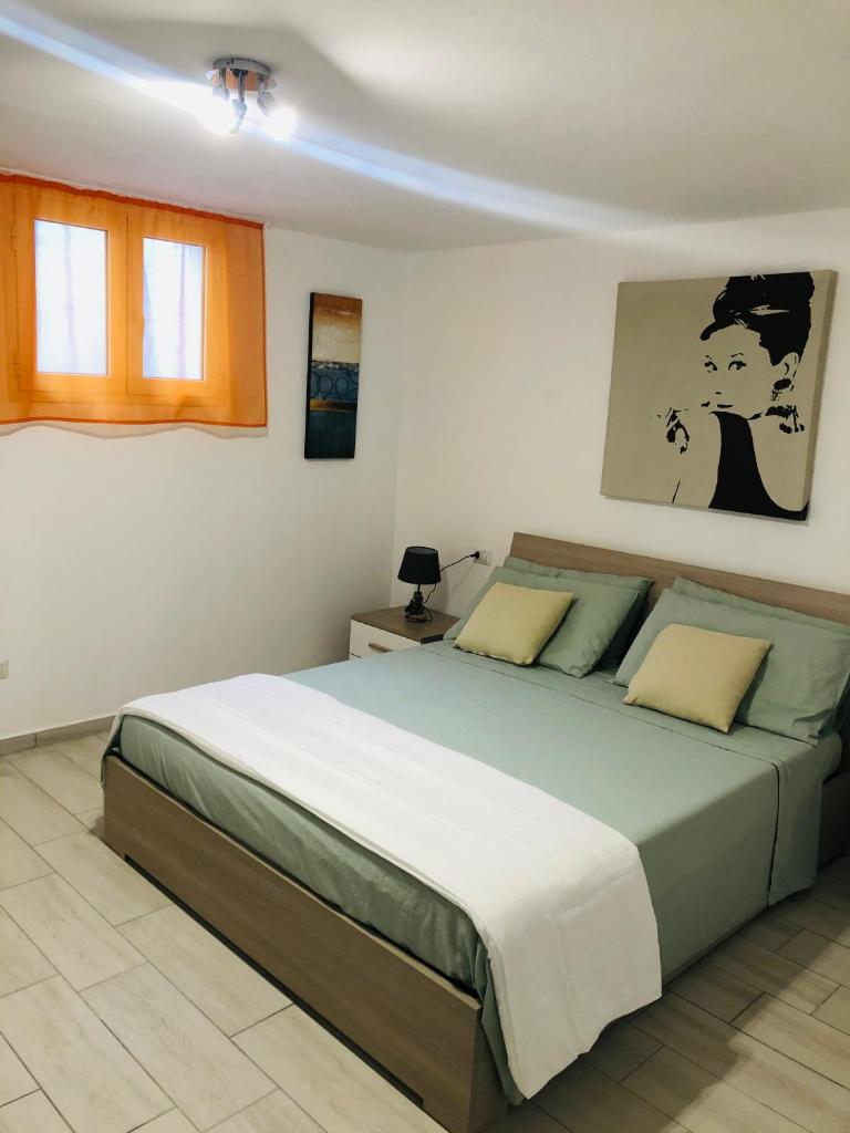 une chambre avec un grand lit dans une pièce dans l'établissement VILLA AMBRA, à Tertenìa