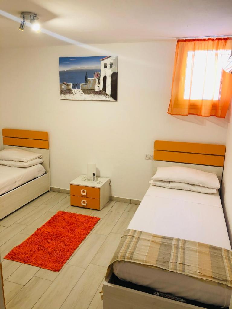 - une chambre avec 2 lits et un tapis rouge dans l'établissement VILLA AMBRA, à Tertenìa