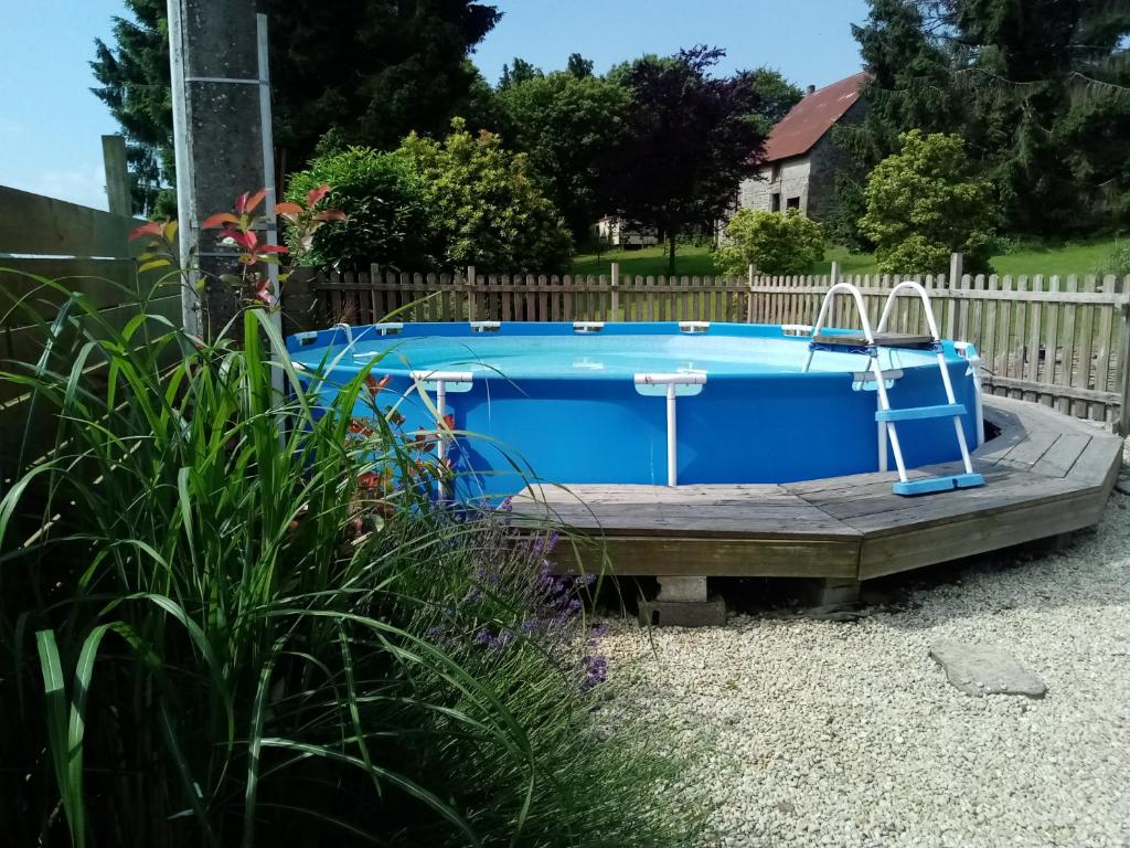 - une piscine dans une cour avec une terrasse en bois dans l'établissement Gite L'insinière, à Saint-Martin-de-Chaulieu