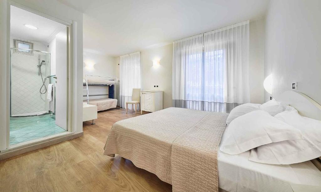 une chambre avec un grand lit et une salle de bain dans l'établissement Family Hotel Antibes -50m dal mare -, à Riccione 22 autres photos