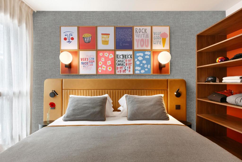 - une chambre avec un lit et un mur avec des affiches dans l'établissement RockyPop Flaine Appartements & Spa, à Flaine