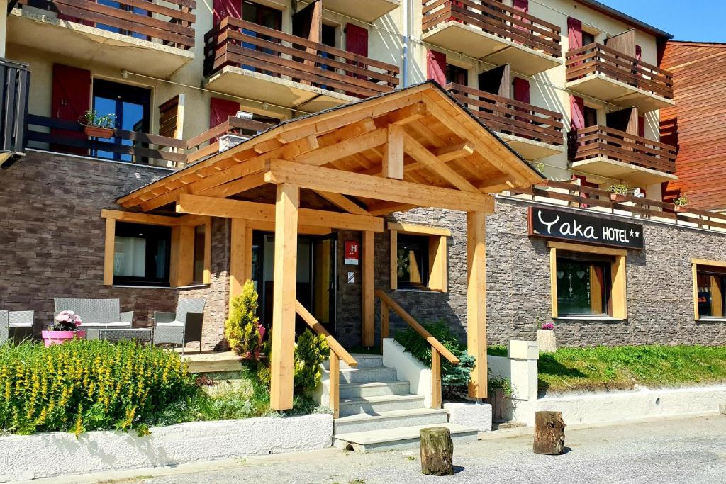 un bâtiment avec un auvent en bois en face de celui-ci dans l'établissement Hôtel Yaka, aux Angles 24 autres photos