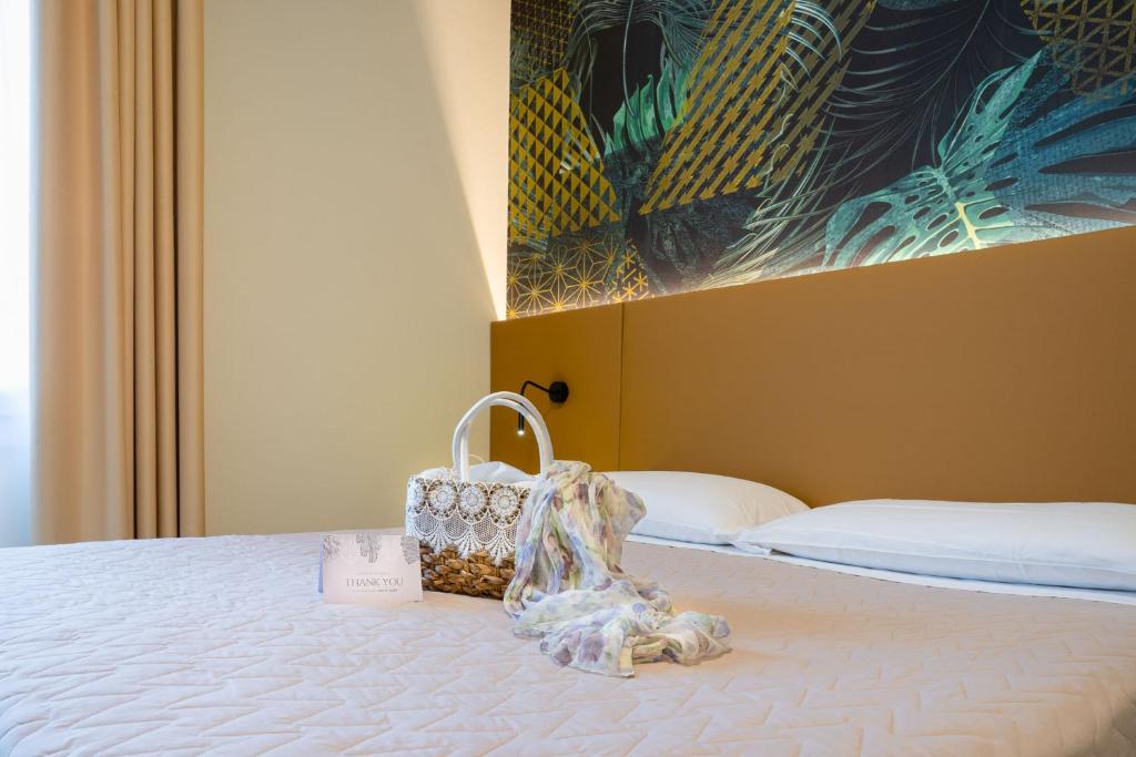 Cette chambre d'hôtel dispose d'un lit avec un porte-monnaie. dans l'établissement Hotel Suez, à Lido di Jesolo