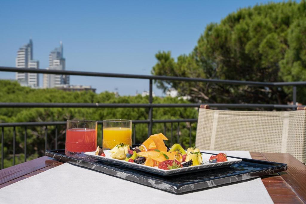 un plateau de nourriture sur une table avec deux verres de jus dans l'établissement Hotel Suez, à Lido di Jesolo