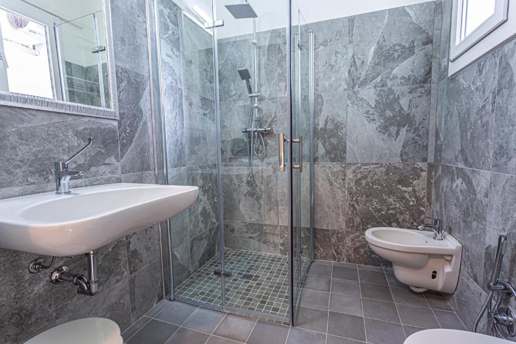 une salle de bain avec douche, lavabo et toilettes dans l'établissement Hotel Rio Beach & Breakfast, à Cesenatico 47 autres photos