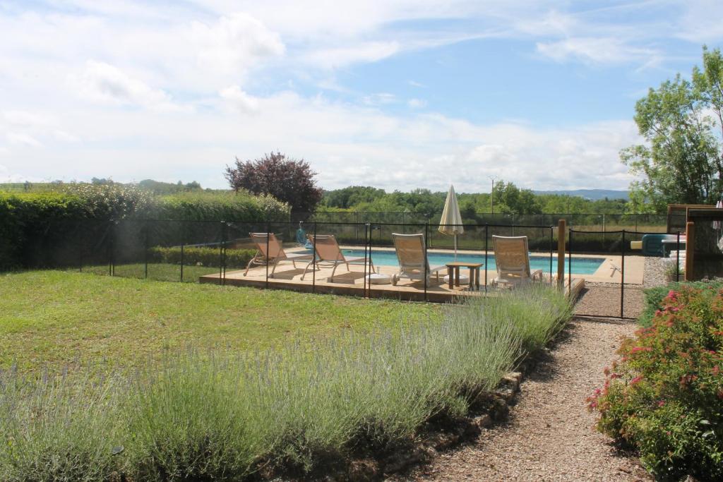 une cour avec des chaises et une piscine dans l'établissement Gîte Le Pressoir, à Cahuzac-sur-Vère