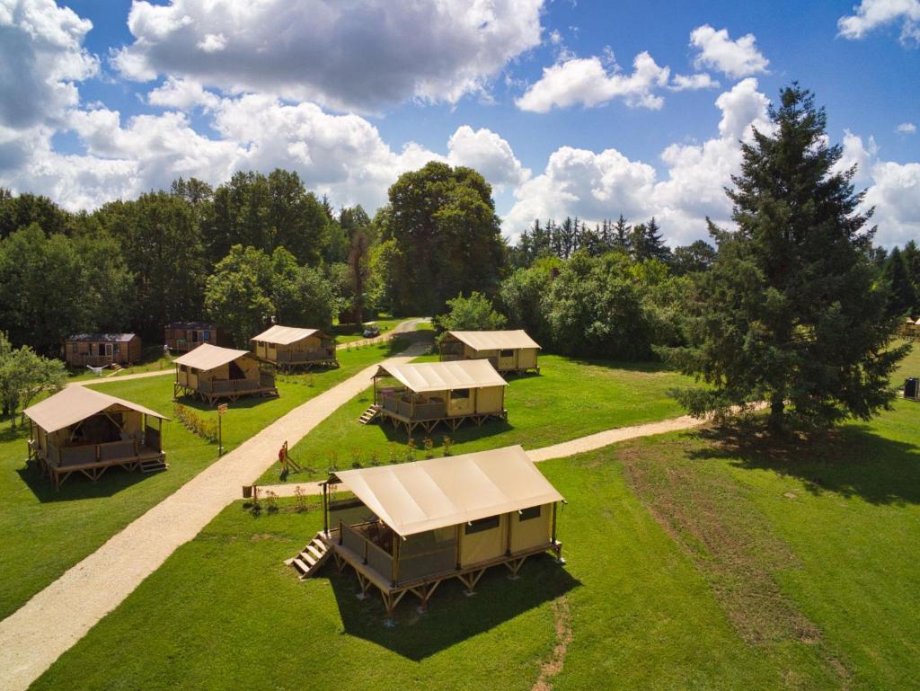 Vue de tête d'un groupe de lodges dans un champ dans l'établissement Le Domaine du Bois Coquet, à La Douze
