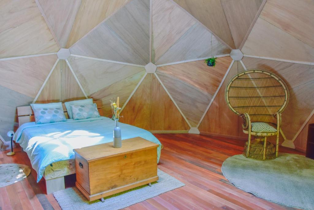 - une chambre avec un lit et une chaise dans une tente dans l'établissement Les Insolites du Domaine d'Haulmé, à Haulmé