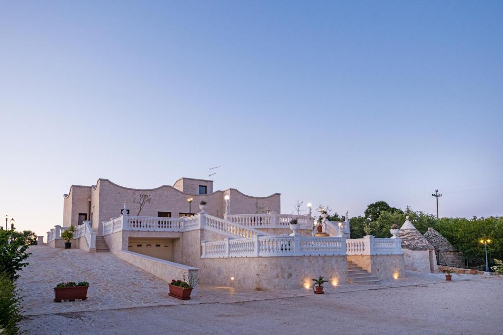 un grand bâtiment avec un escalier en face de celui-ci dans l'établissement Villa Clara, à Alberobello