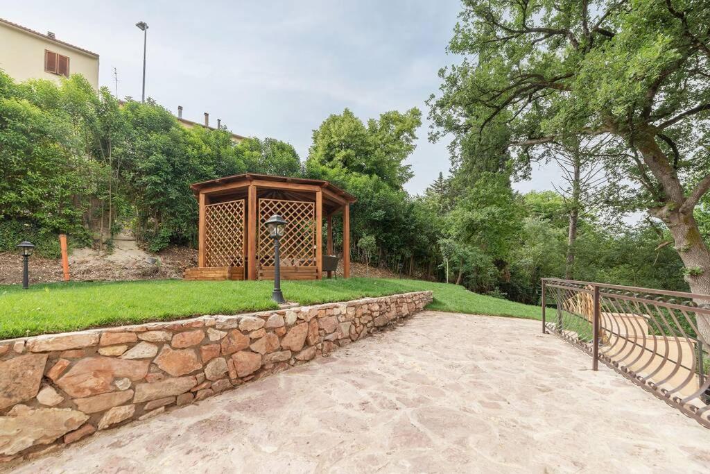 un mur en pierre et une structure en bois dans un parc dans l'établissement Villa Gina Umbria Luxury Retreat, à SantʼAnatolia di Narco