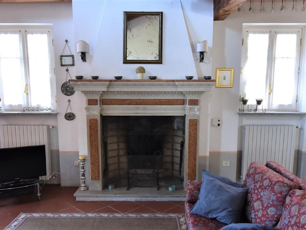 un salon avec une cheminée et une télévision dans l'établissement Villa Ca' del Vento by Interhome, à Montù Beccaria