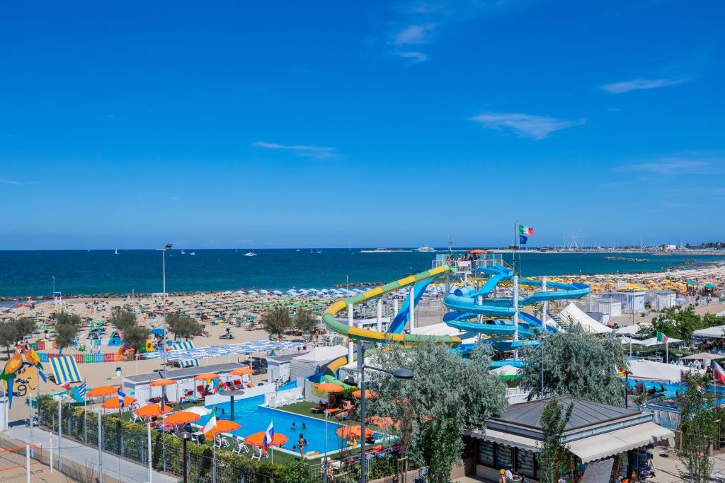 un parc d'attractions avec des toboggans et une plage dans l'établissement Hotel Baby, à Rimini