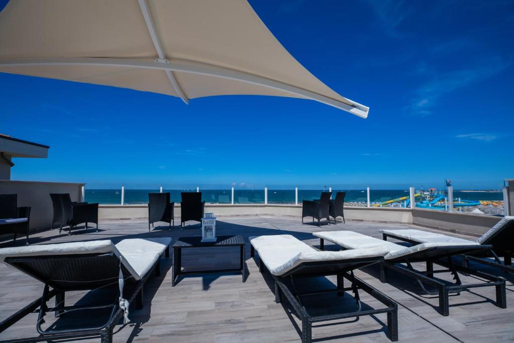 un patio avec une table, des chaises et un parasol dans l'établissement Hotel Baby, à Rimini