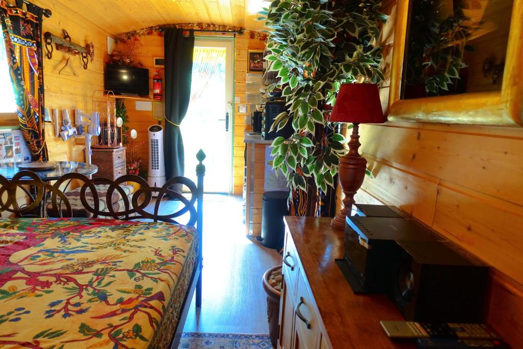 une chambre avec un lit et un bureau avec une lampe dans l'établissement La Ferme De Chenevier, La Roulotte Fleurie 2/4pers, à Saint-Victor