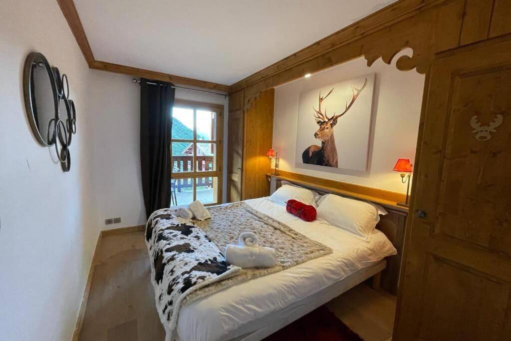 - une chambre dotée d'un lit avec une photo de cerf sur le mur dans l'établissement ARC 1950 Appartement de Standing rénové avec vue sur le Mont Blanc - Paradiski 5 Cristaux, à Arc 1950