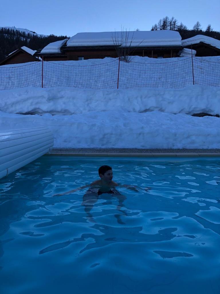 un garçon nageant dans une piscine avec neige dans l'établissement Skis aux pieds station 1800 Dame Blanche, à Puy-Saint-Vincent