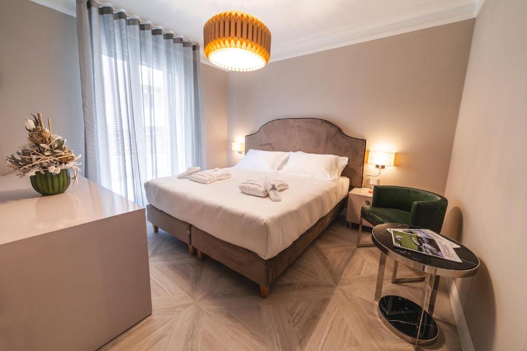 une chambre avec un grand lit et une chaise verte dans l'établissement Brasil Seaview Hotel, à Milano Marittima 122 autres photos