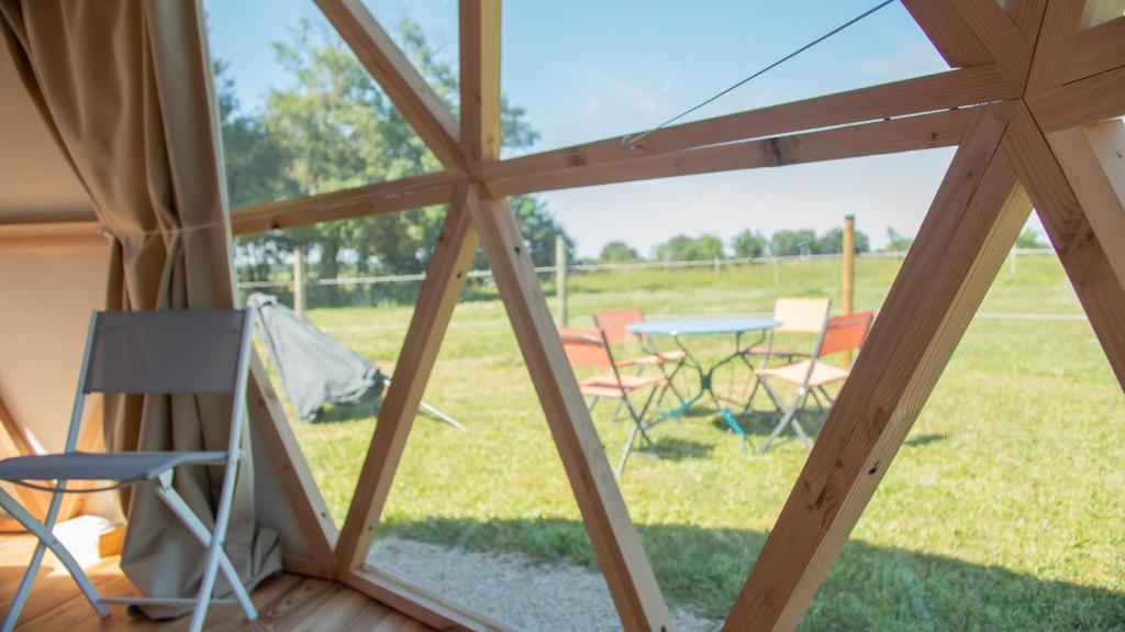 une vue d'une tente avec une table et des chaises dans l'établissement Dome Géodésique, à Gizay