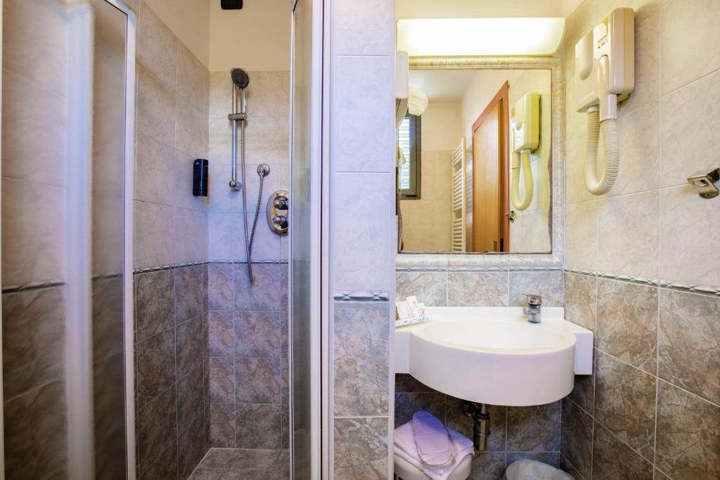une salle de bain avec un lavabo et une douche dans l'établissement Miramare Hotel Ristorante Convegni, à Cesenatico