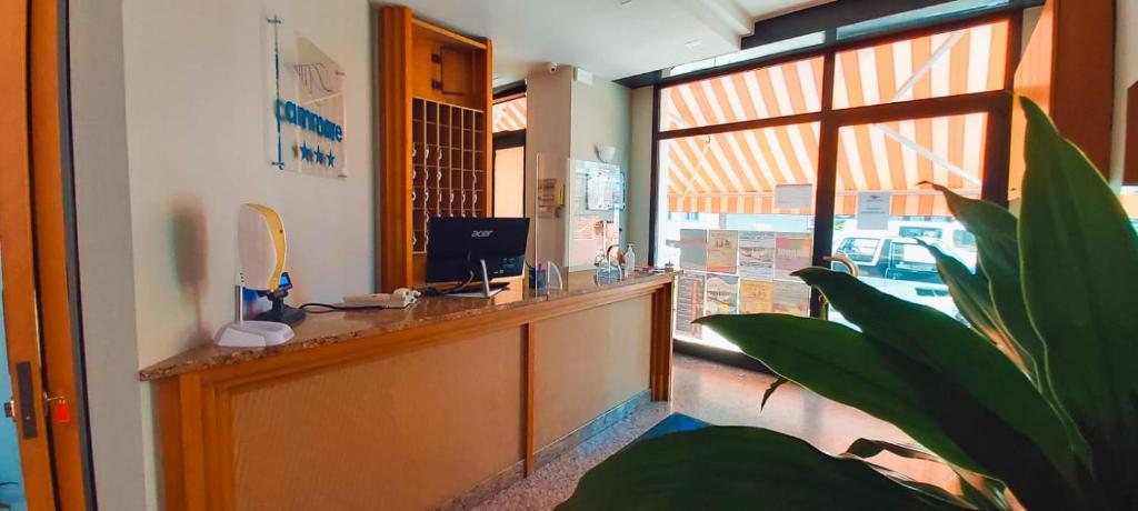 un bureau de réception dans une pièce avec une grande fenêtre dans l'établissement Hotel Ammare, à Sottomarina