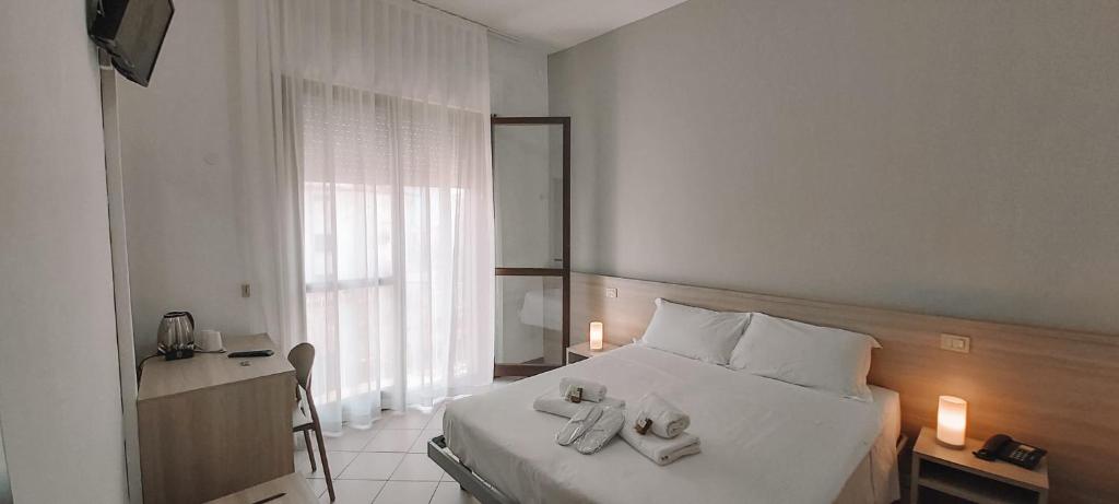 une chambre d'hôtel avec un lit avec des serviettes dessus dans l'établissement Hotel Ammare, à Sottomarina