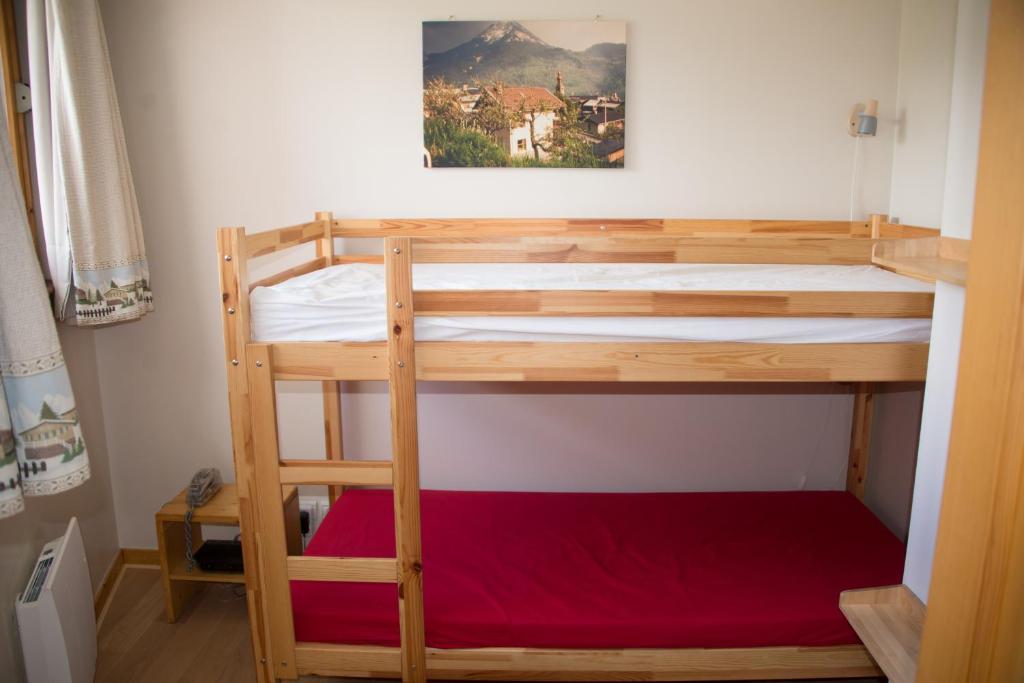 Ce lit superposé se trouve dans une petite chambre dotée d'un matelas rouge. dans l'établissement Courchevel 1550 – VERITABLE SKI AUX PIEDS – APPARTEMENT LES TOVETS T2 – 47m2 – 4P, à Courchevel
