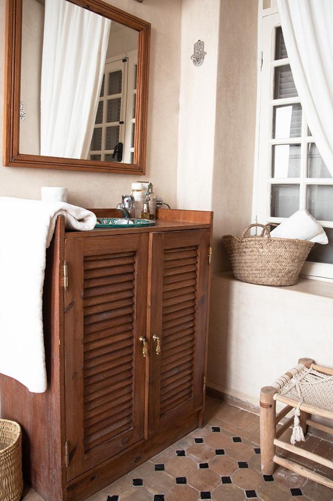 La salle de bains est pourvue d'une armoire en bois et d'un miroir. dans l'établissement Riad Lyon-Mogador, à Essaouira 19 autres photos