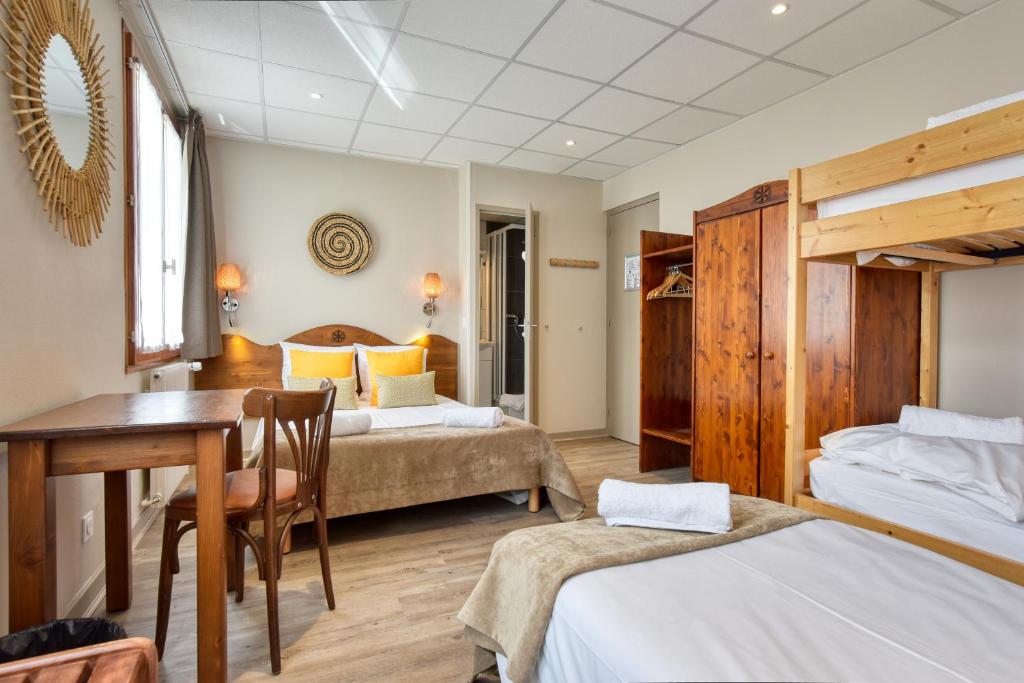 une chambre avec deux lits, une table et un bureau dans l'établissement Hôtel Les Essarts, USSIM Vacances, à Valloire