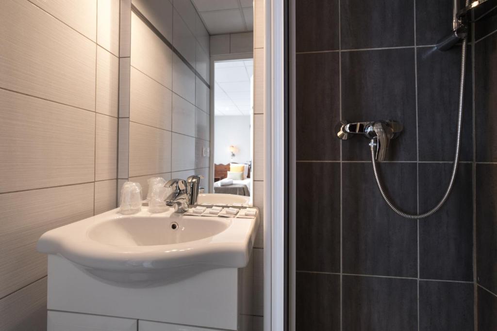 une salle de bain avec un lavabo et une douche dans l'établissement Hôtel Les Essarts, USSIM Vacances, à Valloire