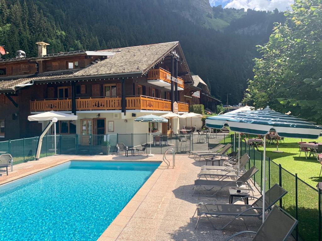 un hôtel avec une piscine et une maison dans l'établissement Hameau des Prodains - Hôtel, à Morzine