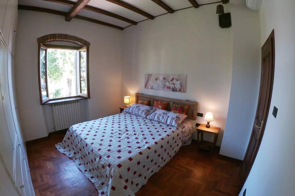 - une chambre avec un lit, une fenêtre et 2 lampes dans l'établissement La Menchina ( Alloggio privato), à Arezzo