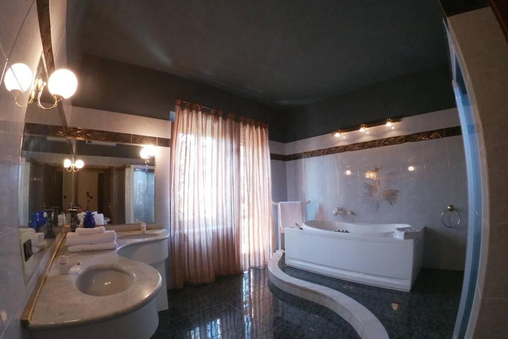 La grande salle de bains est pourvue de 2 lavabos, d'une baignoire et d'une baignoire. dans l'établissement La Menchina ( Alloggio privato), à Arezzo