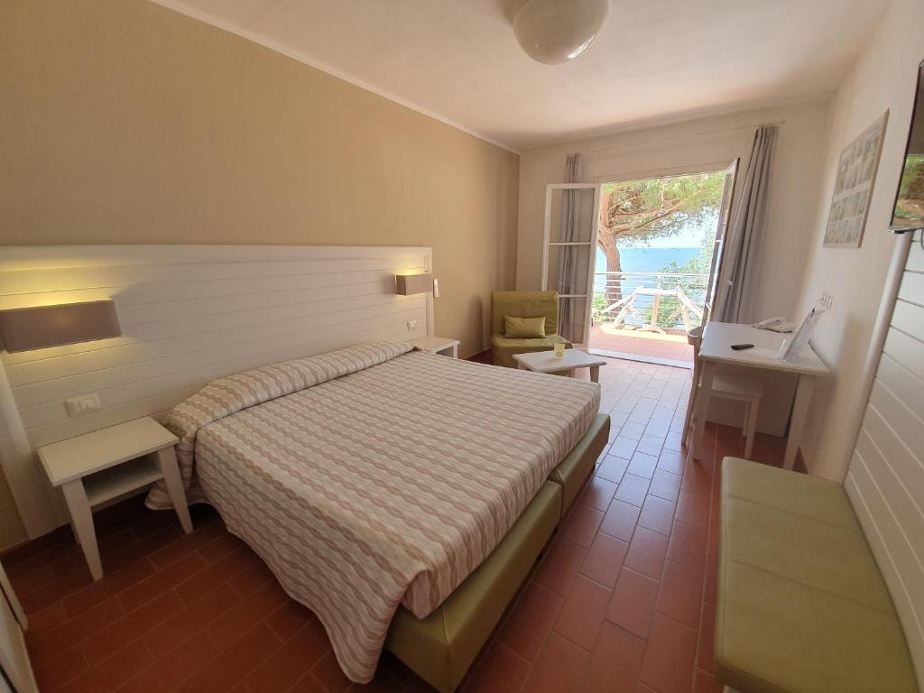 une chambre avec un lit et une grande fenêtre dans l'établissement Hotel Mare, à Portoferraio