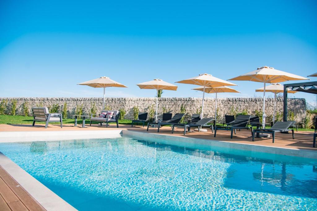 une piscine avec chaises et parasols dans l'établissement Modica Boutique Hotel, à Modica