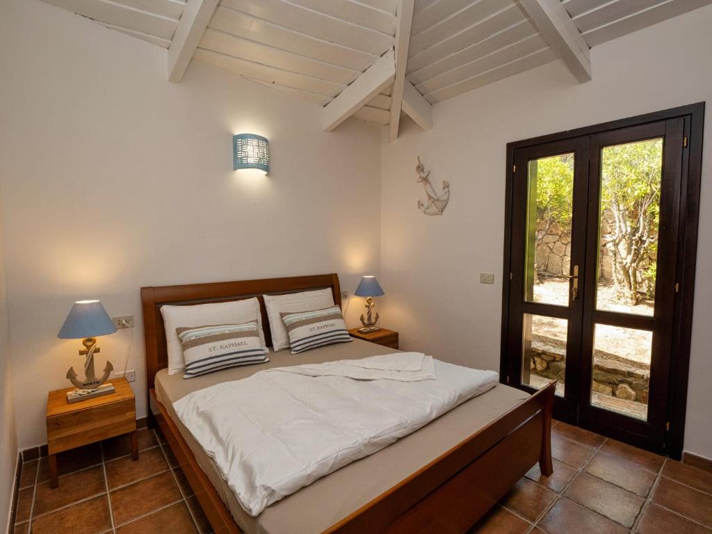 une chambre avec un lit dans une pièce avec une fenêtre dans l'établissement Villa Luna Rossa con piscina, à San Teodoro