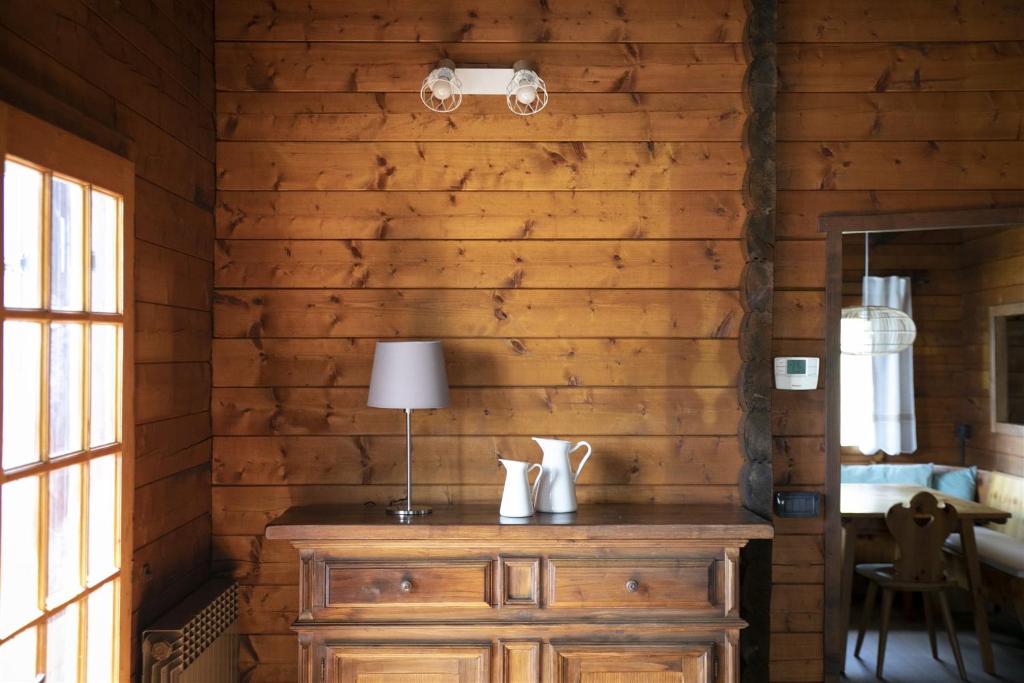 Cette chambre est dotée d'un mur en bois et d'une table avec une lampe. dans l'établissement IseoLakeRental - Villa Alessandra, à Riva di Solto