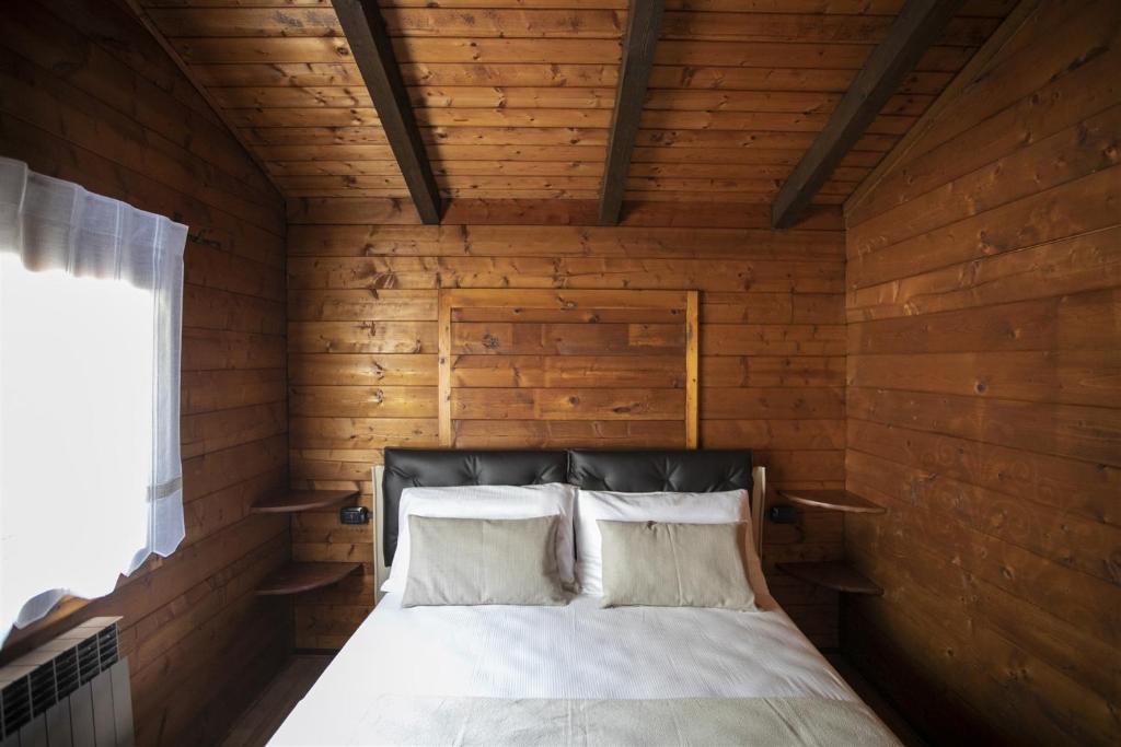 une chambre avec un lit dans une pièce en bois dans l'établissement IseoLakeRental - Villa Alessandra, à Riva di Solto