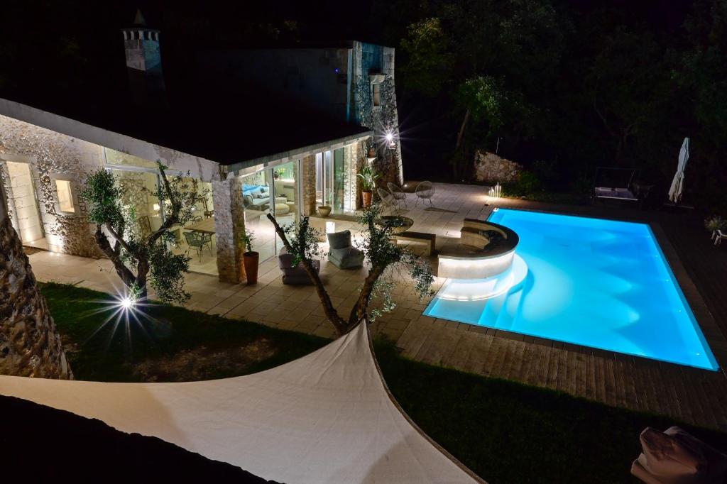 - une vue sur la piscine la nuit dans l'établissement Tenuta i rosoni, à Cursi