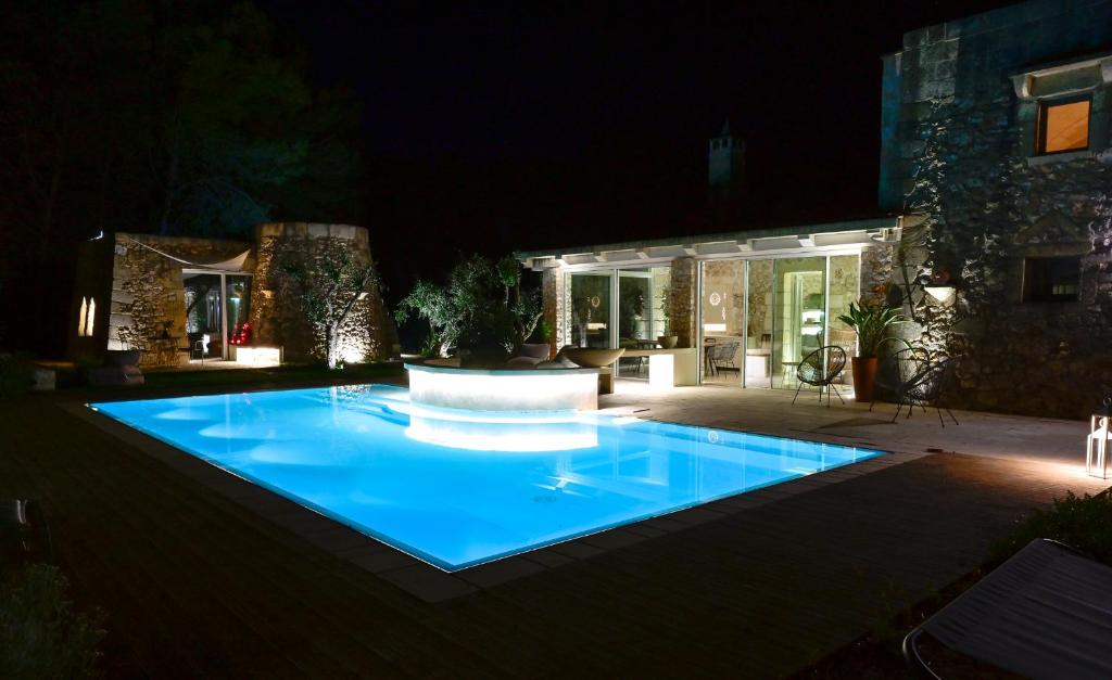 une piscine dans une cour la nuit dans l'établissement Tenuta i rosoni, à Cursi