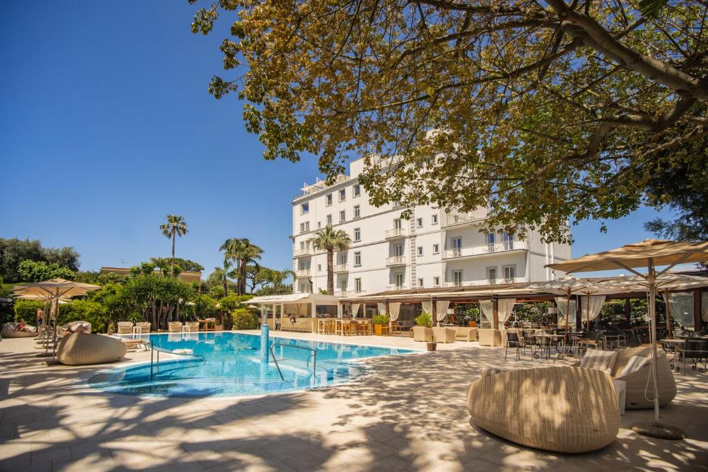 un hôtel avec une piscine dotée de chaises et de parasols dans l'établissement Hotel Mediterraneo, à Sant'Agnello