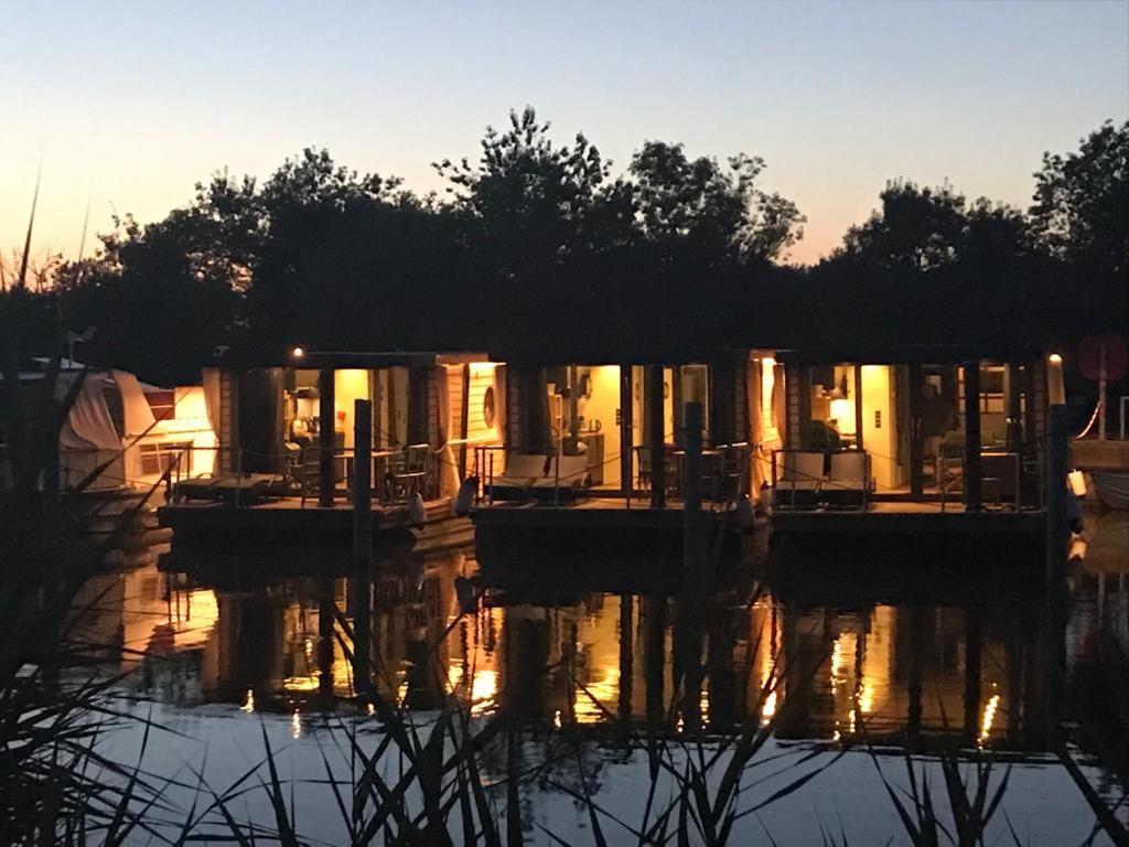 une maison sur un quai dans l'eau au coucher du soleil dans l'établissement Rêves d'Ô en Camargue, clim réversible, parc naturel, à Vauvert