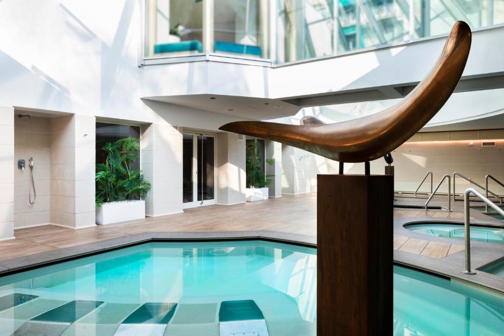 - une piscine dans un bâtiment avec une baignoire en bois dans l'établissement Grand Hotel Alassio Beach & Spa Resort - The Leading Hotels of the World, à Alassio