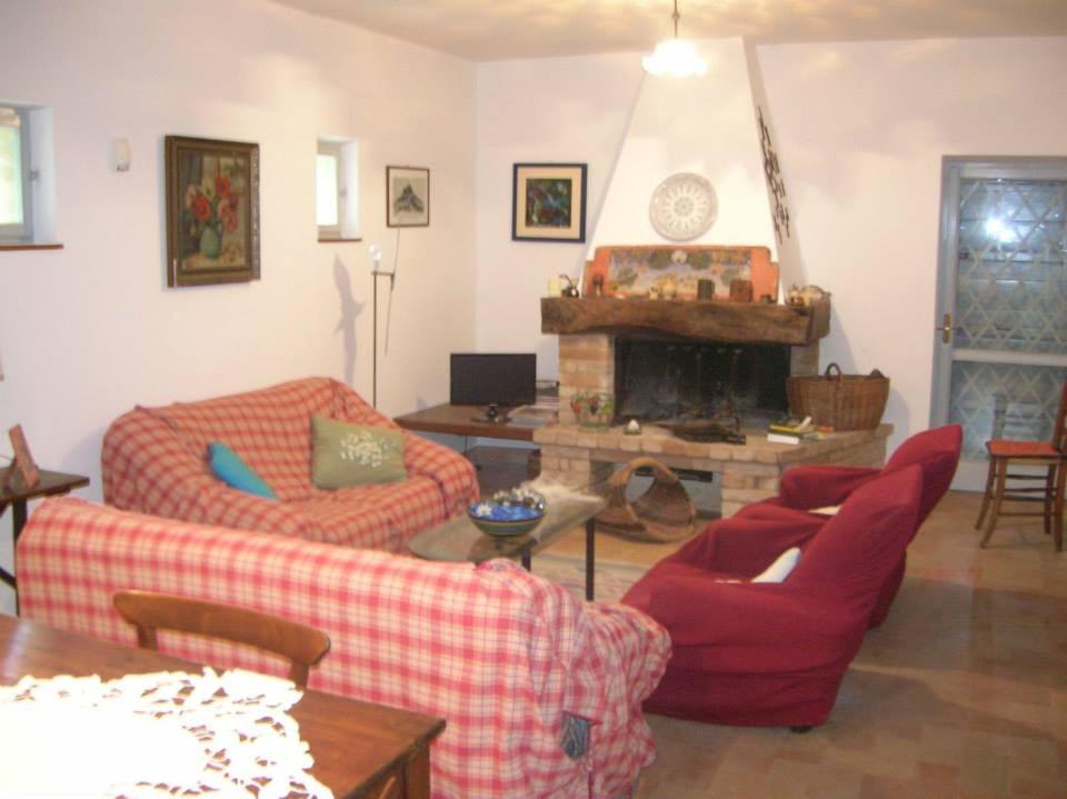 un salon avec deux canapés et une cheminée dans l'établissement Country House "I luoghi dell' anima"con piscina e giardino, à Montottone