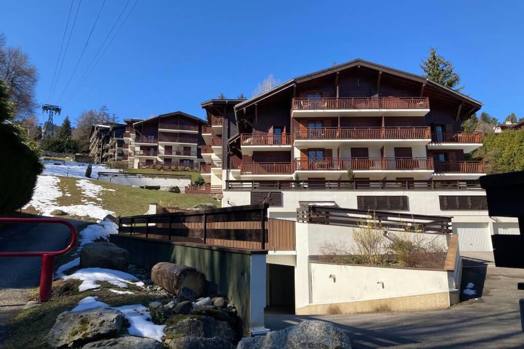 un grand bâtiment en face d'une rivière dans l'établissement Appartement l'Edel - Vue Massif Mont-Blanc, à Saint-Gervais-les-Bains