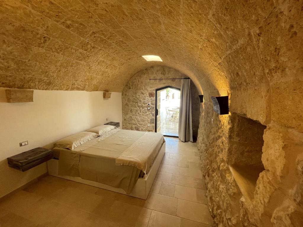 - une chambre avec 2 lits dans un mur en pierre dans l'établissement Le Liame Antico Trullo, à Gagliano del Capo