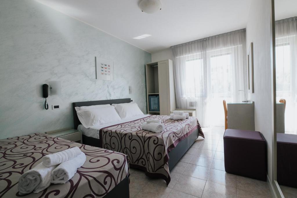 une chambre d'hôtel avec deux lits et une fenêtre dans l'établissement Hotel Gloria, à Lignano Sabbiadoro 47 autres photos